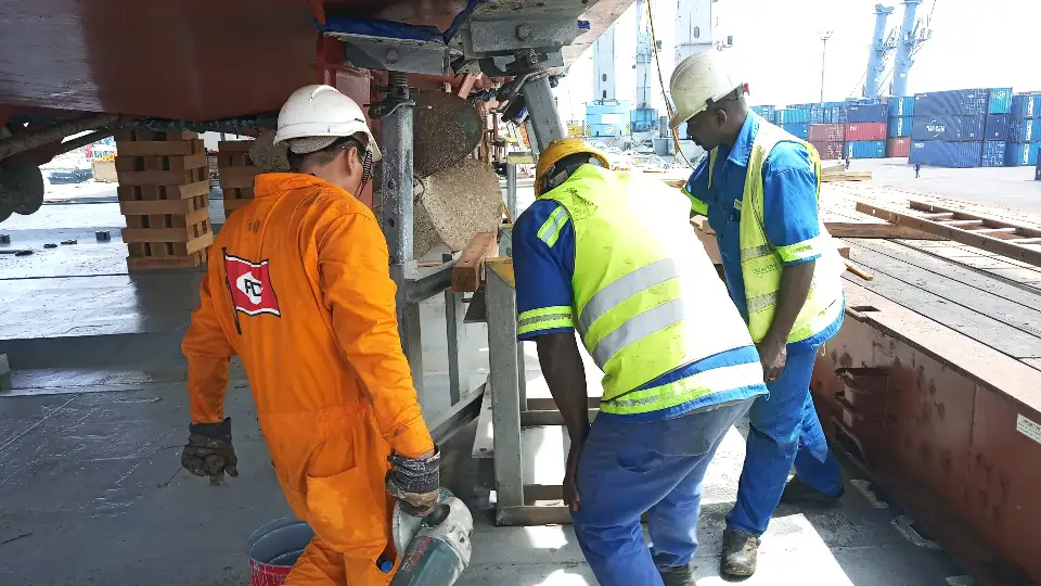 travailleurs sur un chantier naval en maintenance, pour reparer l'helice d'un bateau au port
